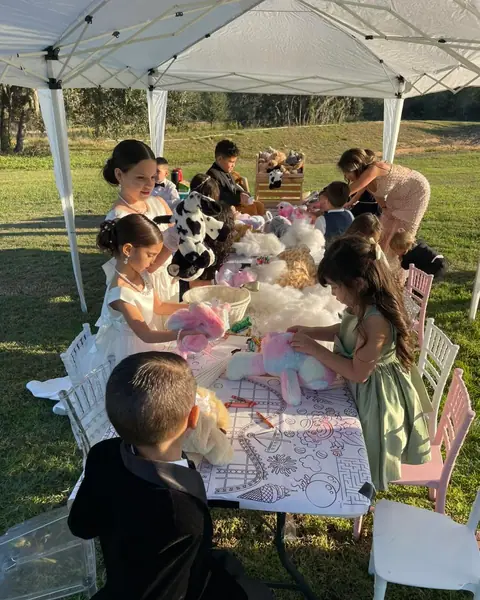 Kids stuffing bears at an outdoor build-a-bear table