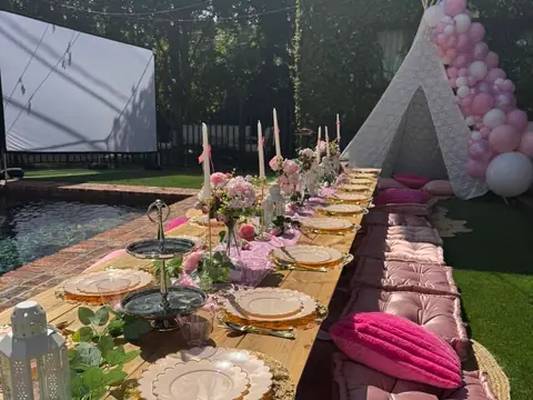 Pink poolside luxury picnic with a balloon teepee and movie screen