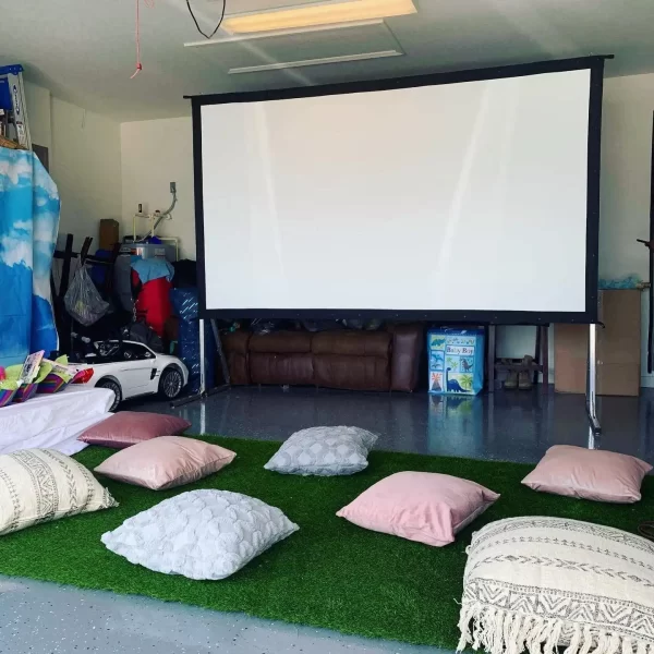 A garage with the Ultimate Movie Night Setup Training Package - Transform Your Events and pillows on the floor.