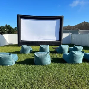 A backyard Ultimate Movie Night Setup Training Package - Transform Your Events set up with bean bags in the grass.