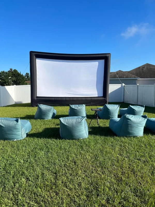 A backyard Ultimate Movie Night Setup Training Package - Transform Your Events set up with bean bags in the grass.
