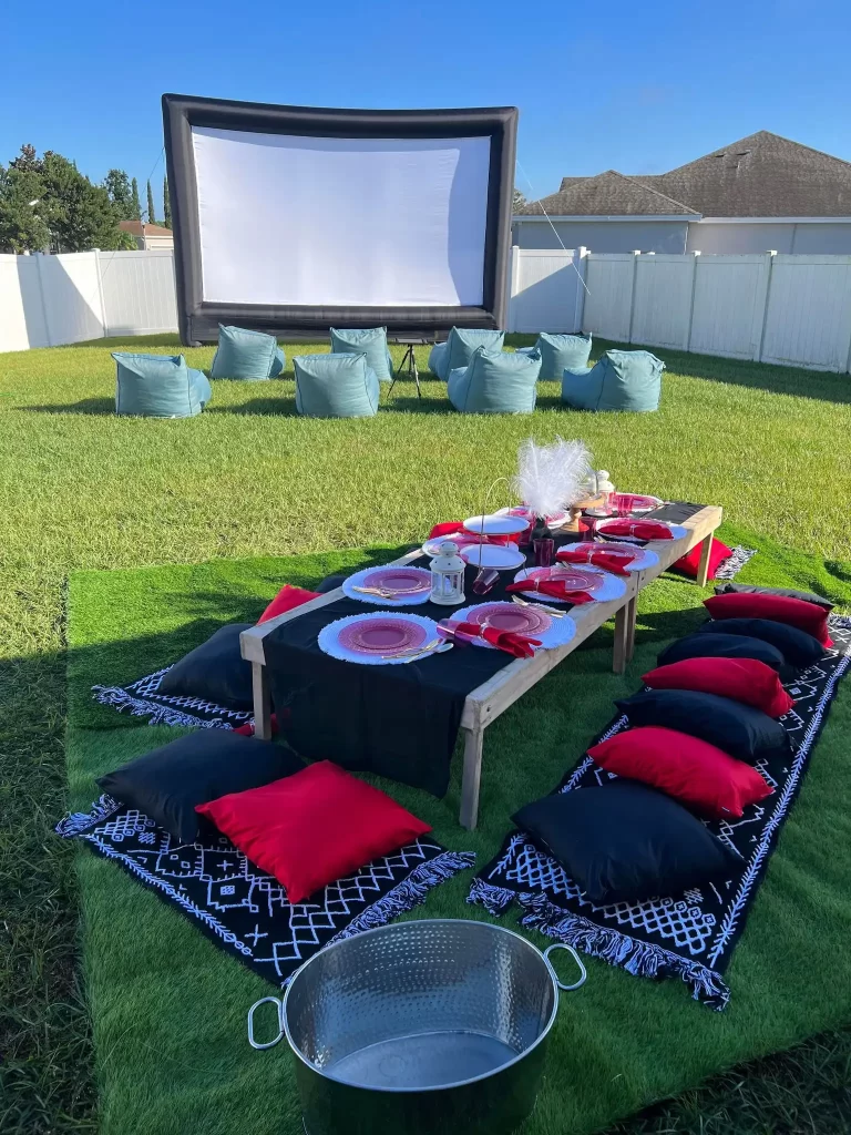 A backyard Ultimate Movie Night Setup Training Package - Transform Your Events with pillows and a movie screen.