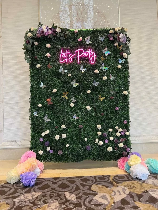 A green wall with flowers and a sign that says Complete Add-on List party.