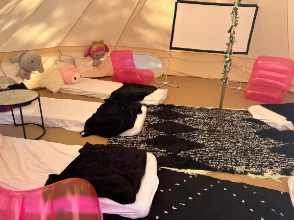 A group of people are sleeping in the Ultimate Movie Night Setup Training Package - Transform Your Events tent.