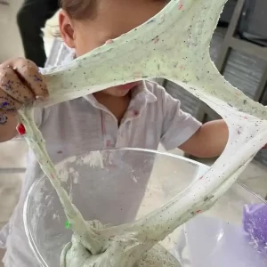 A child is playing with the Ultimate Slime Party Training Package.